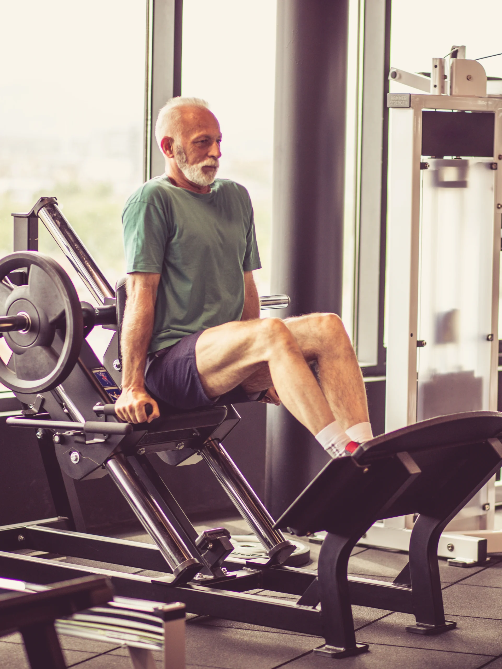 a mature man using exercise equipment to strengthen his knee and prevent pain