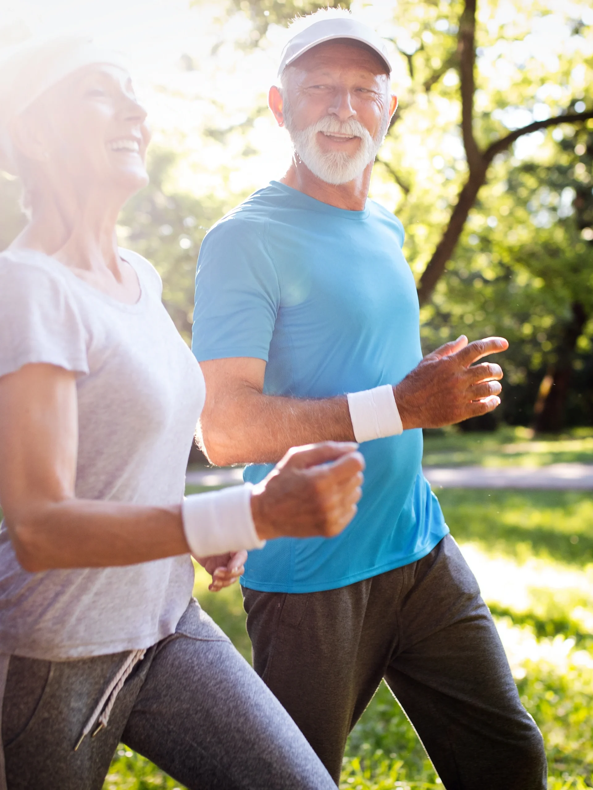 a happy mature couple running outside together and free of knee pain