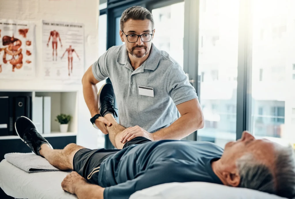 physiotherapist examining his patient's knee for the source of his knee pain